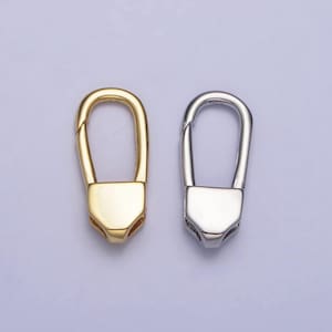 May include: Two metal keychains, one gold and one silver, with a simple oval loop design.