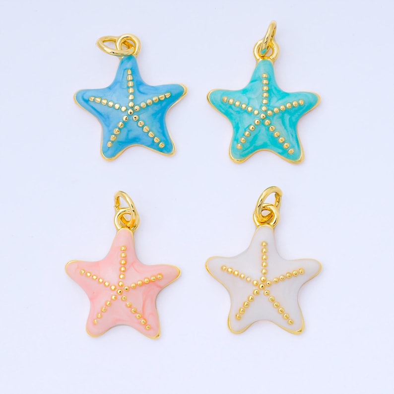 May include: Four starfish charms in shades of blue, teal, pink, and white, each with a gold-colored border and dotted accents. The charms have a loop at the top for attaching to jewelry. These charms are perfect for beach-themed jewelry.