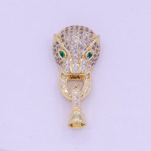 May include: Gold-tone pendant featuring a detailed jaguar head design with clear and green cubic zirconia stones.