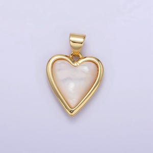 May include: A gold heart-shaped pendant with a white mother-of-pearl inlay.