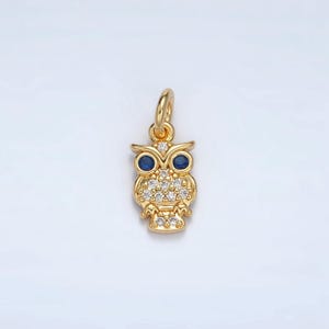 May include: A gold owl charm with blue eyes and clear rhinestones. The owl is a popular symbol of wisdom and knowledge.