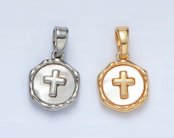 May include: Two silver and gold pendants with a white cross on a white background. The pendants are shaped like a circle with a textured edge.