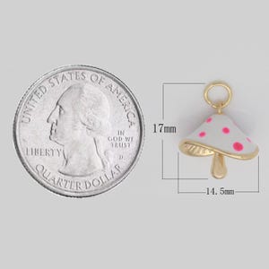 May include: Gold-tone mushroom charm with white enamel and pink polka dots. The charm is 17 mm tall and 14.5 mm wide.