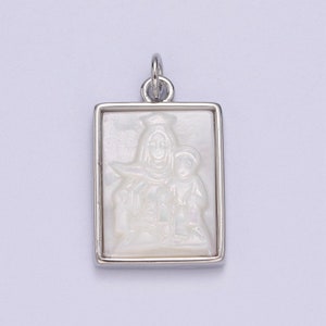 May include: A silver pendant with a white mother of pearl inlay depicting the Virgin Mary and child. The pendant is rectangular and has a silver frame.