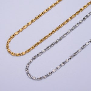 Può includere: Due collane a catena, una dorata e una argentata, con un designo unico del link. Le catene sono disposte su uno sfondo bianco.