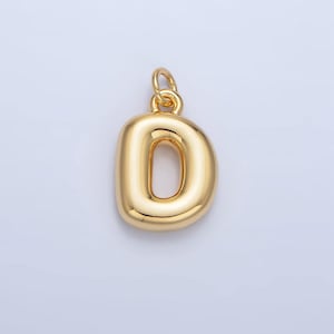 May include: A gold-colored charm in the shape of the letter D. The charm has a smooth, rounded surface and a hole at the top for attaching to a necklace or bracelet.