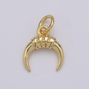 Peut inclure: Breloque en métal doré en forme de croissant de lune avec des cornes détaillées. Le breloque a une boucle en haut pour l'attacher à un collier ou un bracelet.