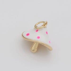 May include: Gold-tone mushroom charm with white enamel and pink polka dots.