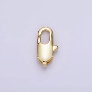 May include: Gold-toned metal clasp with a spring-loaded closure. The clasp is designed for attaching jewelry or other items.