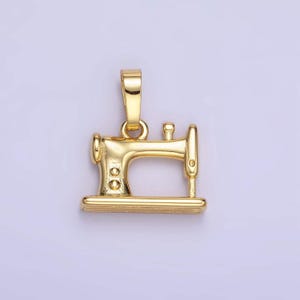 May include: A gold-colored metal charm in the shape of a sewing machine. The charm has a loop at the top for attaching to a necklace or bracelet.
