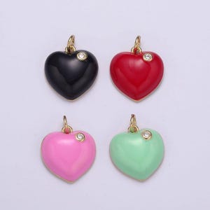 May include: Four enamel heart charms with a single rhinestone on each. The charms are black, red, pink, and green.