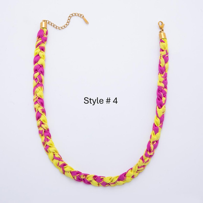 May include: A braided necklace featuring alternating strands of yellow and magenta fabric. The necklace has a gold-colored chain and clasp. The text "Style # 4" is printed on the white background.