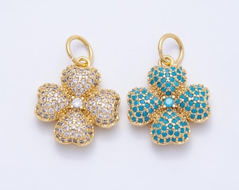 May include: Two gold-colored clover charms, one with clear crystals and the other with turquoise-colored stones. Each charm has a small loop at the top for hanging. The charms are set against a white background.