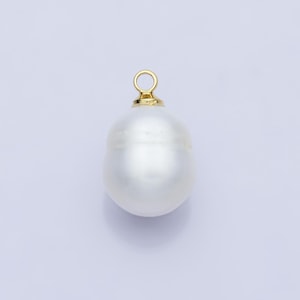 Op de afbeelding: Een witte barokke parel hanger met een goudkleurige beugel. De parel heeft een onregelmatige vorm en een glad, reflecterend oppervlak. De beugel is een kleine, cirkelvormige lus om aan een ketting of ander sieraad te bevestigen.