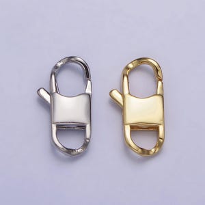 May include: Two metal lobster clasps, one silver and one gold. The clasps are a common jewelry finding used for necklaces, bracelets, and other jewelry.