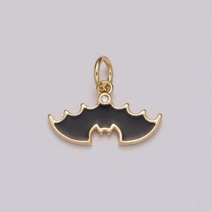 Pingente delicado de morcego em esmalte preto e dourado, com formato de vassoura, perfeito para o Halloween. Ideal para colares, pulseiras e brincos.