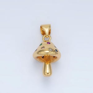 May include: A gold mushroom pendant with a detailed design and colorful gemstones. The pendant has a loop at the top for attaching to a chain.