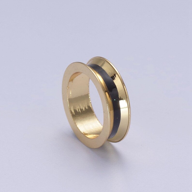 Peut inclure: Une bague en or avec une bande noire autour du centre.