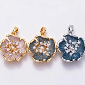 May include: Three flower-shaped pendants featuring enamel petals in light pink, slate gray, and deep blue. Each pendant is accented with small white faux pearls and clear crystals at the center, finished with a metallic bail for hanging.