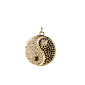 Könnte beinhalten: Goldene Halskette mit Anhänger in Form eines Yin-Yang-Symbols mit schwarzen und weißen Zirkonia-Steinen.