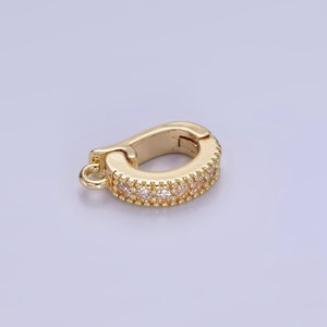 May include: Gold-toned metal clasp with a row of clear cubic zirconia stones. The clasp is designed to be used as a connector for jewelry.