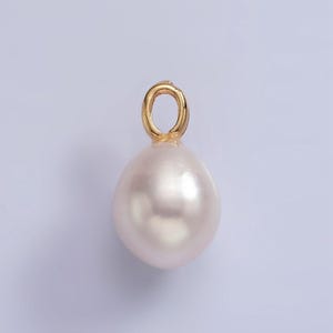 May include: A white pearl pendant with a gold loop for attaching to a necklace or bracelet.