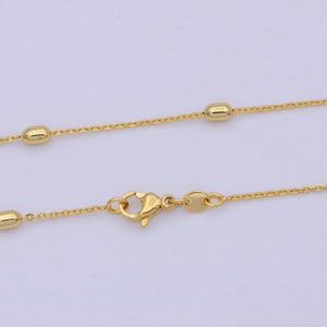 May include: A gold chain necklace with small round beads. The chain has a lobster clasp.