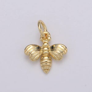May include: A gold bee charm pendant with detailed wings and a textured body.