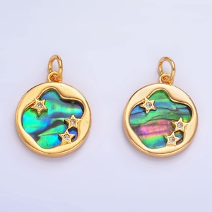 Op de afbeelding: Twee goudkleurige hangers met iriserende abalone schelpinzetstukken. Elke hanger heeft een cirkelvormig frame met drie stervormige accenten. De abalone schelp toont een reeks kleuren, waaronder groen, blauw en paars.
