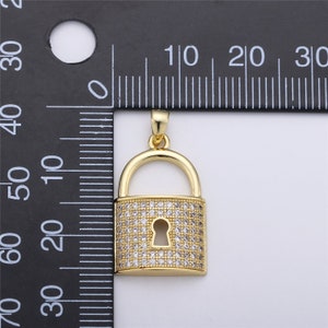 Pu&ograve; includere: Un ciondolo a forma di lucchetto dorato con pietre di zircone cubico trasparenti. Il ciondolo misura circa 2 cm di lunghezza e larghezza.