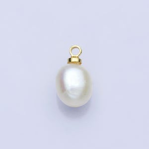 Op de afbeelding: Een crèmewitte parel hanger met een goudkleurige beugel. De parel heeft een gladde, onregelmatige vorm en een subtiele iriserende glans. De gouden beugel is een eenvoudig, elegant ontwerp, perfect voor het maken van sieraden.