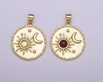 May include: Two gold-toned pendants with a sun and crescent moon design. One pendant has a clear stone in the center of the sun, while the other has a red stone.