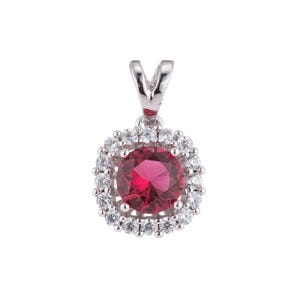 May include: A silver pendant with a red gemstone surrounded by a halo of smaller white gemstones.