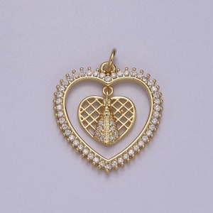 Puede incluir: Un colgante de corazón de oro con un pequeño encanto de corazón en su interior. Ambos corazones están decorados con piedras brillantes transparentes.