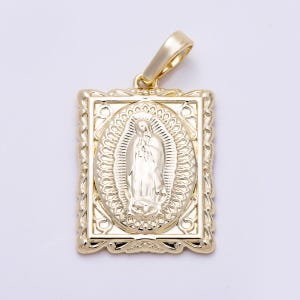 May include: A rectangular gold pendant featuring a central oval relief of the Virgin of Guadalupe. The pendant has a decorative scalloped border and a polished finish. A smooth, tapered gold bail is attached to the top for chain suspension.