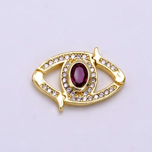 May include: Gold-tone eye charm with a red gemstone and clear crystal accents.
