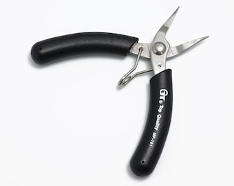 Puede incluir: Alicates de punta fina con mango negro y cuerpo de metal plateado. Los alicates tienen una punta puntiaguda y el texto "GT Top Quality MP-1101" está impreso en el mango.