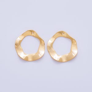 May include: Two gold-coloured earring components. Each has an open-circle shape with a wavy edge and a small hole for attachment. The components have a shiny, reflective surface, suitable for jewellery making.