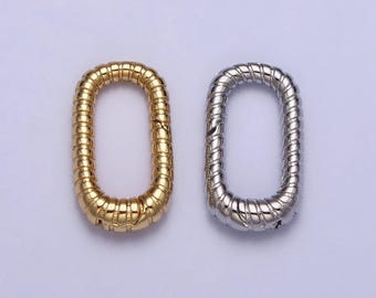 May include: Two metal rings, one gold and one silver, with a twisted design. The rings are oval shaped and have a smooth finish.
