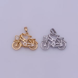 May include: Two bicycle pendants, one gold and one silver, with clear crystal accents. The pendants are in the shape of a bicycle with a basket on the front.