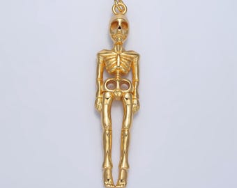May include: A gold-toned skeleton pendant charm. The charm is detailed with a skull and ribcage.