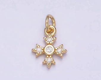 Puede incluir: Un amuleto de color dorado en forma de estrella de cuatro puntas con cinco piedras de circonita cúbica transparentes.