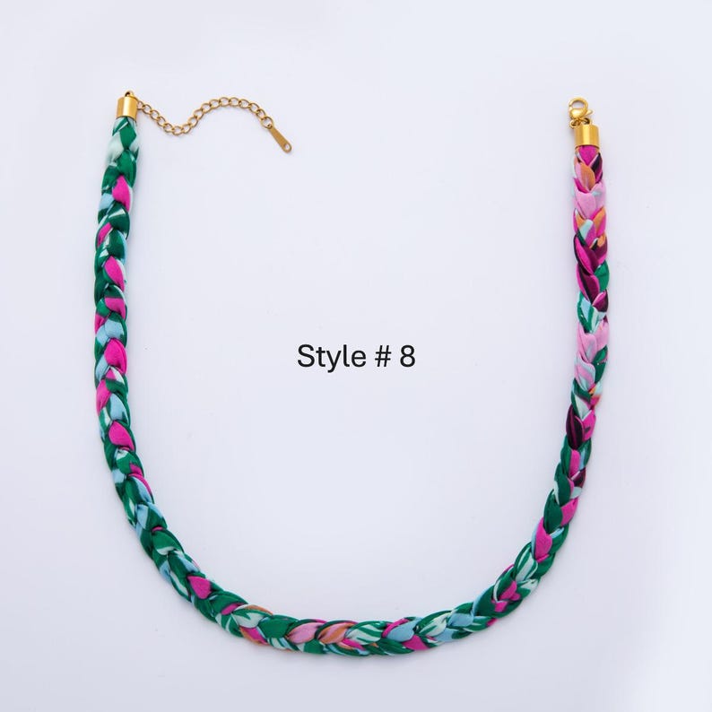 May include: Braided necklace with a vibrant pattern of green, pink, and blue. The necklace has gold-colored metal clasps and a chain. The text "Style # 8" is printed on the background.