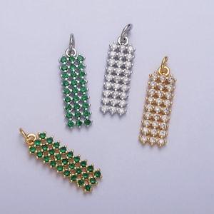 May include: Four pendant charms with a rectangular shape and a chain-like design. Two charms are silver with clear rhinestones, one charm is gold with clear rhinestones, and one charm is gold with green rhinestones.