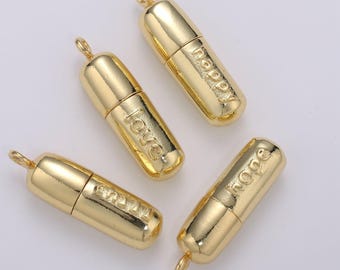 Puede incluir: Cuatro abalorios de color dorado en forma de píldora con diferentes palabras grabadas: "love", "happy", "hope" y "smile".