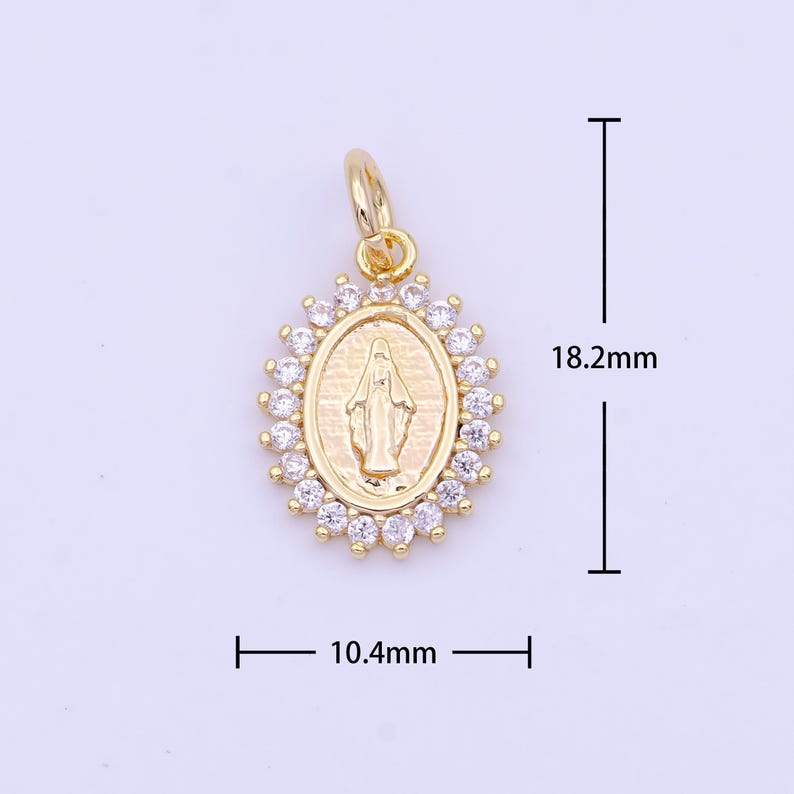 May include: Gold-toned pendant featuring a detailed image of the Virgin Mary surrounded by clear cubic zirconia stones. The pendant measures 1.82 inches in height and 1.04 inches in width.