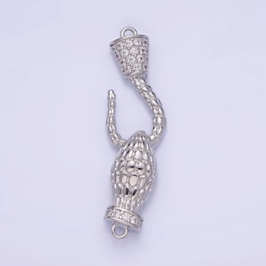 May include: Silver tone metal clasp with a textured, snake-like design and clear cubic zirconia stones. The clasp has a loop on each end.