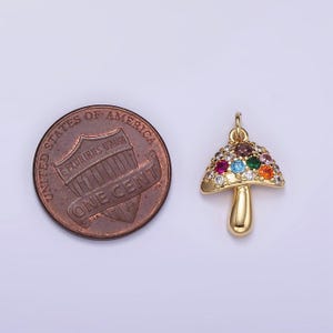 May include: Gold-tone mushroom charm with colorful rhinestones. The charm is about the size of a US penny.