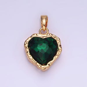 May include: A gold heart-shaped pendant with a large, faceted, green gemstone.