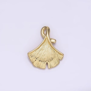 May include: A gold-colored ginkgo leaf pendant charm. The leaf is detailed with veins and has a loop at the top for attaching to a necklace or bracelet.